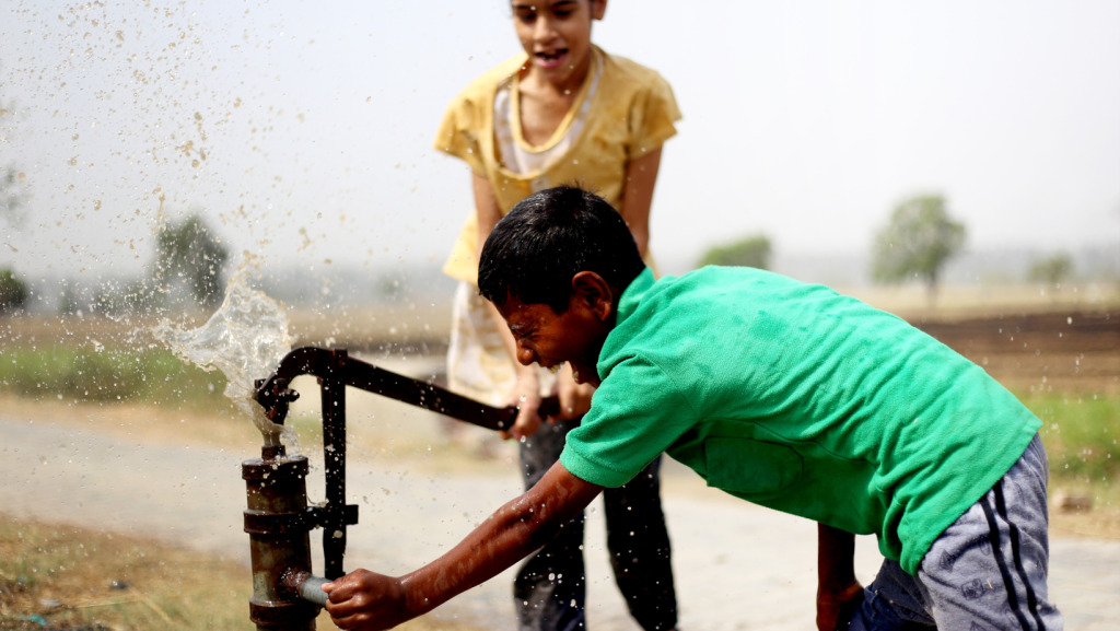 Día Mundial del Agua: Niños alegres con la instalación de agua potable.