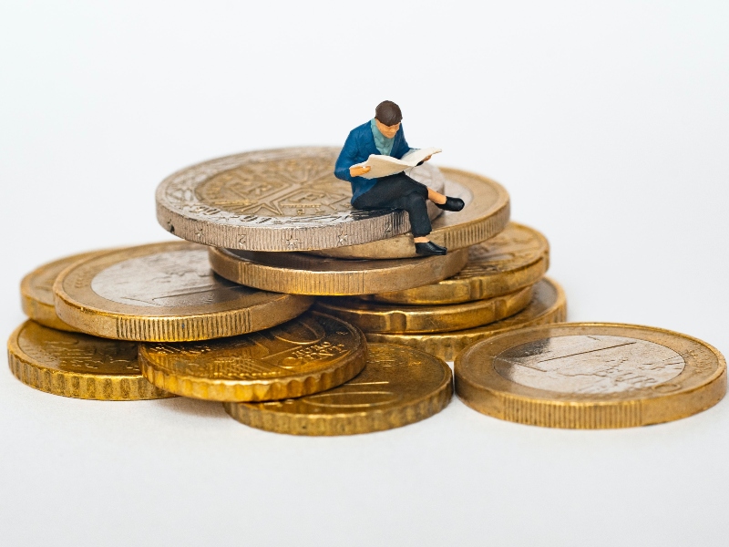 Financiamiento climático: Hombre sentado sobre monedas.